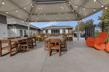 Covered outdoor patio with dining tables and string lights